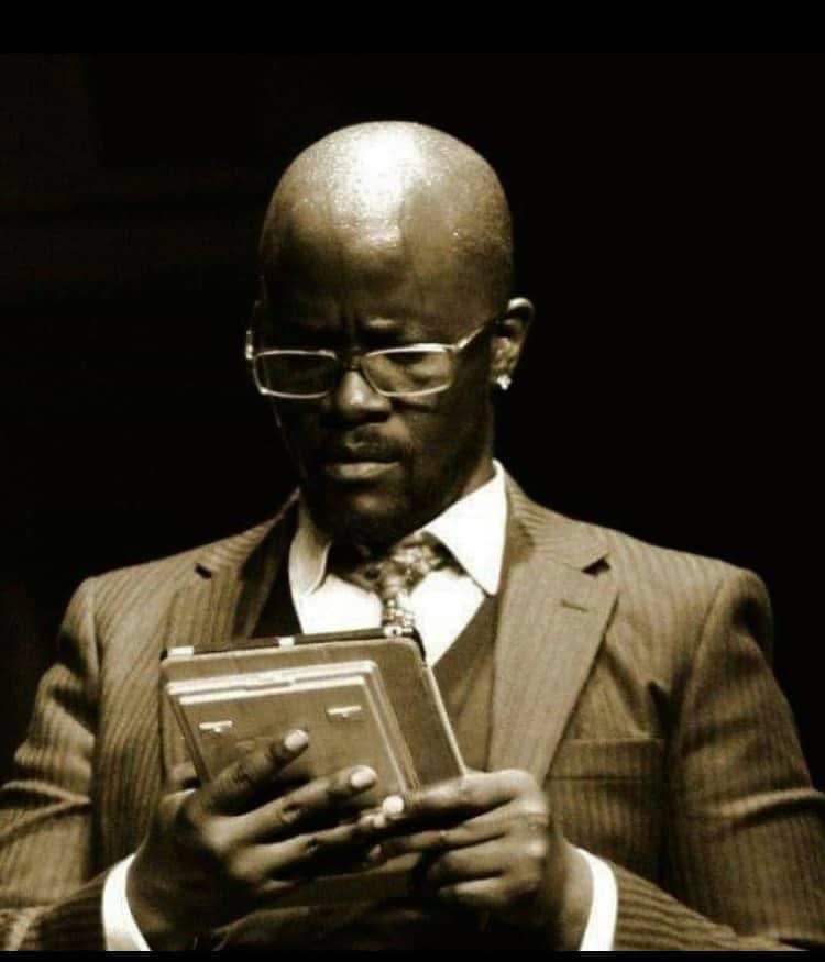 Shylock taking out a large calculator and calculating on stage in The Merchant of Venice.