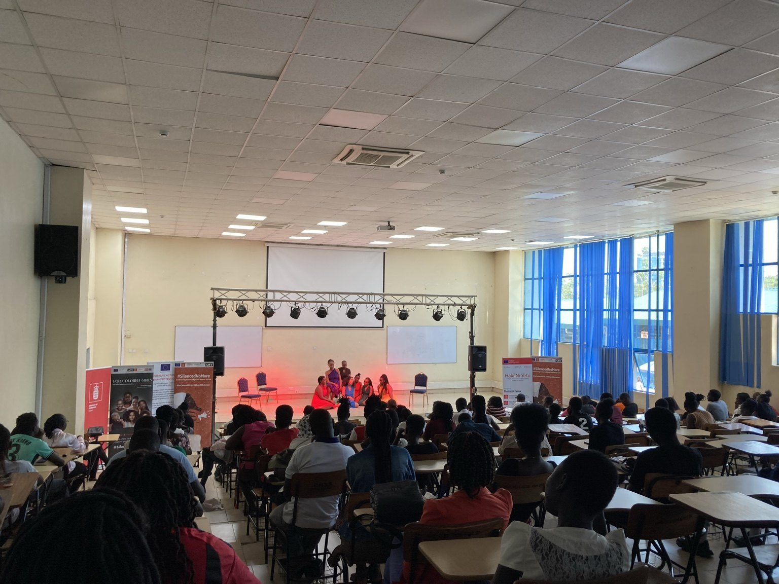 Kisumu University students watching the performance in a lecture hall.
